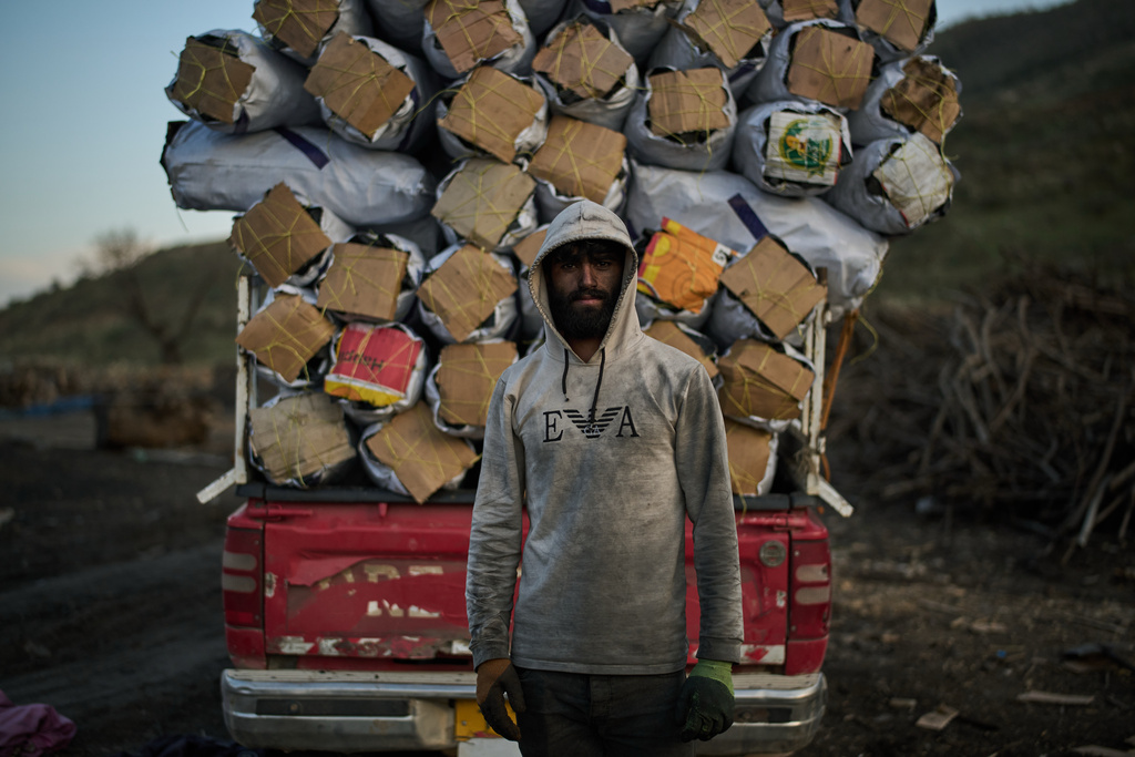 Zana, 22, poses for a photo after loading a vehicle with sacks of charcoal at a traditional production site in Sarkand, Iraq, Thursday, March 12, 2026. (AP Photo/Leo Correa)