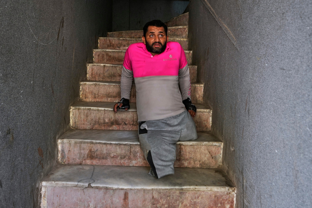 Hamza Ali, 28, who lost both legs in a road accident, moves down a flight of stairs after delivering food in Islamabad, Pakistan, Friday, July 17, 2026. (AP Photo/Anjum Naveed)