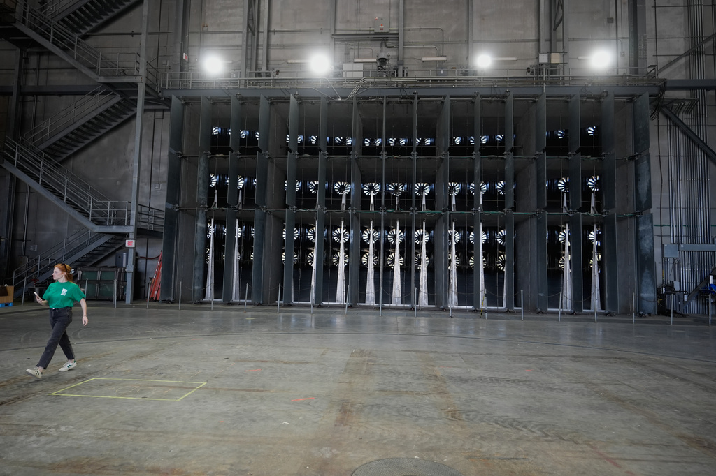 A person walks near fans used for wildfire research at the Institute for Business & Home Safety center on Thursday, April 16, 2026, in Richburg, S.C. (AP Photo/Erik Verduzco)