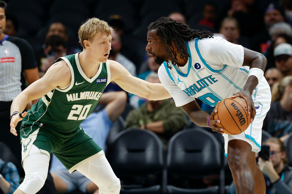 Charlotte Hornets center Naz Reid, right, looks to drive against Milwaukee Bucks guard AJ Green (20) during the first half of a preseason NBA basketball game in Charlotte, N.C., Sunday, Oct. 11, 2026. (AP Photo/Nell Redmond)