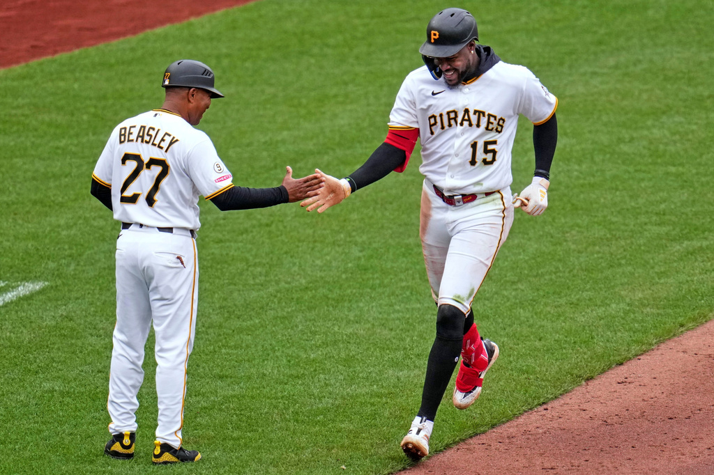 Pittsburgh Pirates' Oneil Cruz (15) is greeted by third base coach Tony Beasley as he rounds third base after hitting a two-run home run off Baltimore Orioles pitcher Cade Povich during the sixth inning of a baseball game in Pittsburgh, Sunday, April 5, 2026. (AP Photo/Gene J. Puskar)