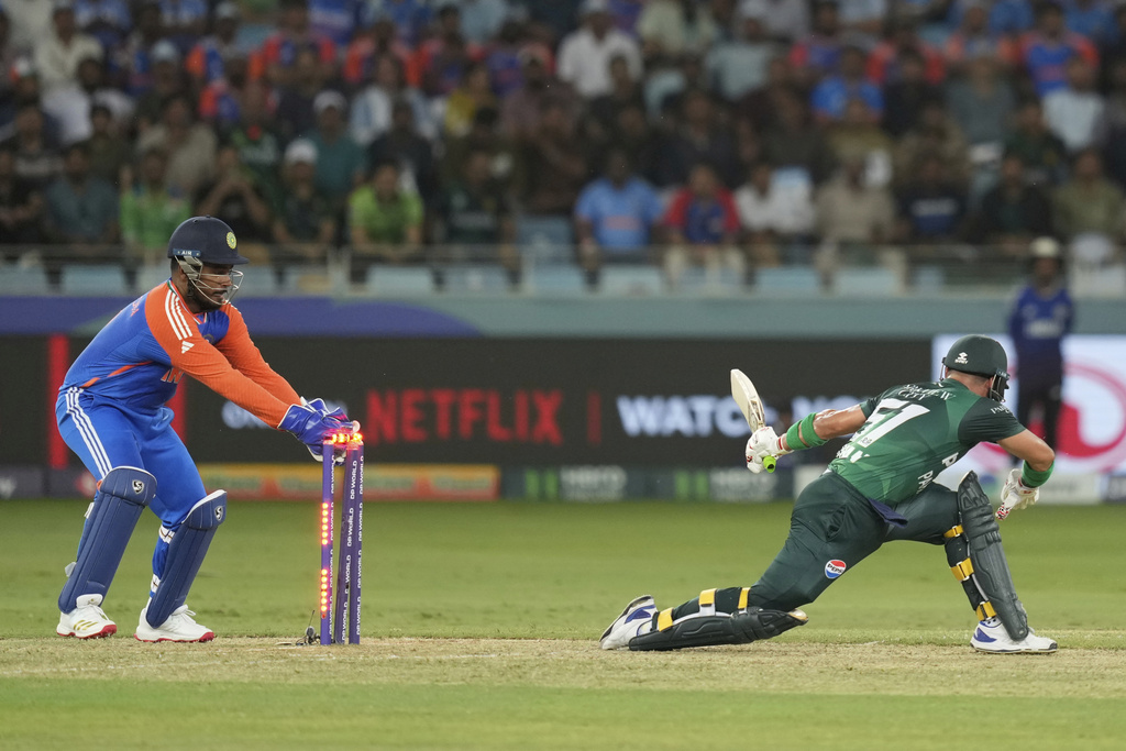 India's Sanju Samson, left, attempts unsuccessfully to stump Pakistan's Sahibzada Farhan during the Asia Cup cricket match between India and Pakistan at Dubai International Cricket Stadium in Dubai, United Arab Emirates, Sunday, Sept. 21, 2025. (AP Photo/Altaf Qadri)