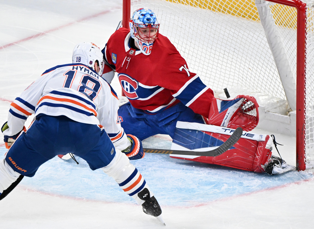 Montreal Canadiens goaltender Jakub Dobes (75) stops Edmonton Oilers' Zach Hyman (18) during the first period of an NHL hockey game, in Montreal, Sunday, Dec. 14, 2025. (Graham Hughes/The Canadian Press via AP)