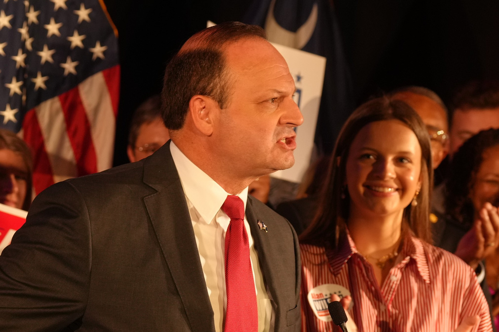 As his daughter, Anna Grace, looks on, South Carolina Attorney General Alan Wilson, left, speaks to supporters as he celebrates his GOP gubernatorial runoff victory in a hotel ballroom on Tuesday, June 23, 2026, in Columbia, S.C. (AP Photo/Meg Kinnard)