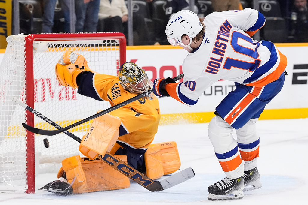 Nashville Predators goaltender Juuse Saros (74) blocks a shootout shot on goal by New York Islanders right wing Simon Holmstrom (10) during overtime of an NHL hockey game Thursday, Jan. 8, 2026, in Nashville, Tenn. (AP Photo/George Walker IV)