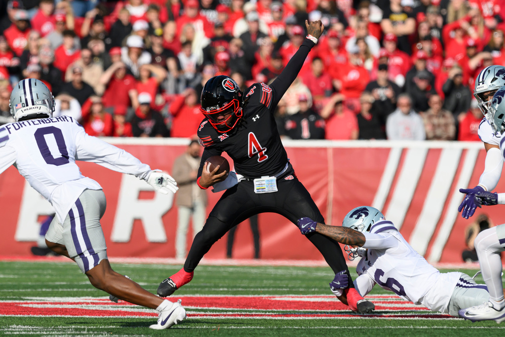 Utah quarterback Devon Dampier (4) is tackled by Kansas State defensive back Qua Moss, bottom right, during the first half of an NCAA college football game, Saturday, Nov. 22, 2025, in Salt Lake City. (AP Photo/Tyler Tate)