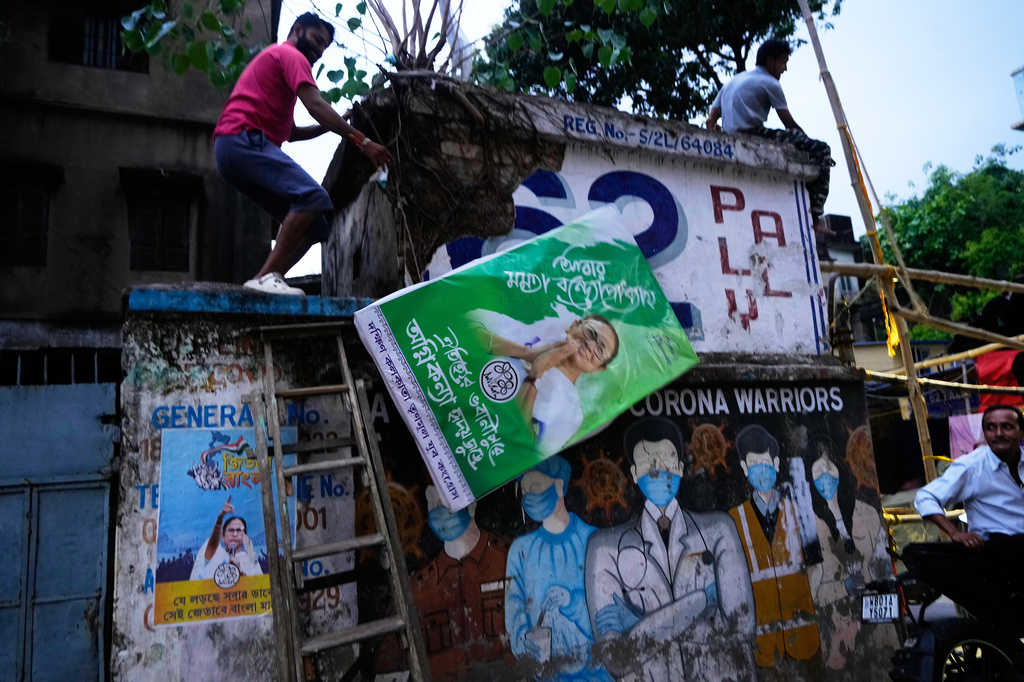 A supporter dismantles an election billboard bearing a portrait of Trinamool Congress chief Mamata Banerjee after the party failed to secure a majority in the West Bengal Legislative Assembly election, in Kolkata, India, Monday, May 4, 2026. (AP Photo/Bikas Das)