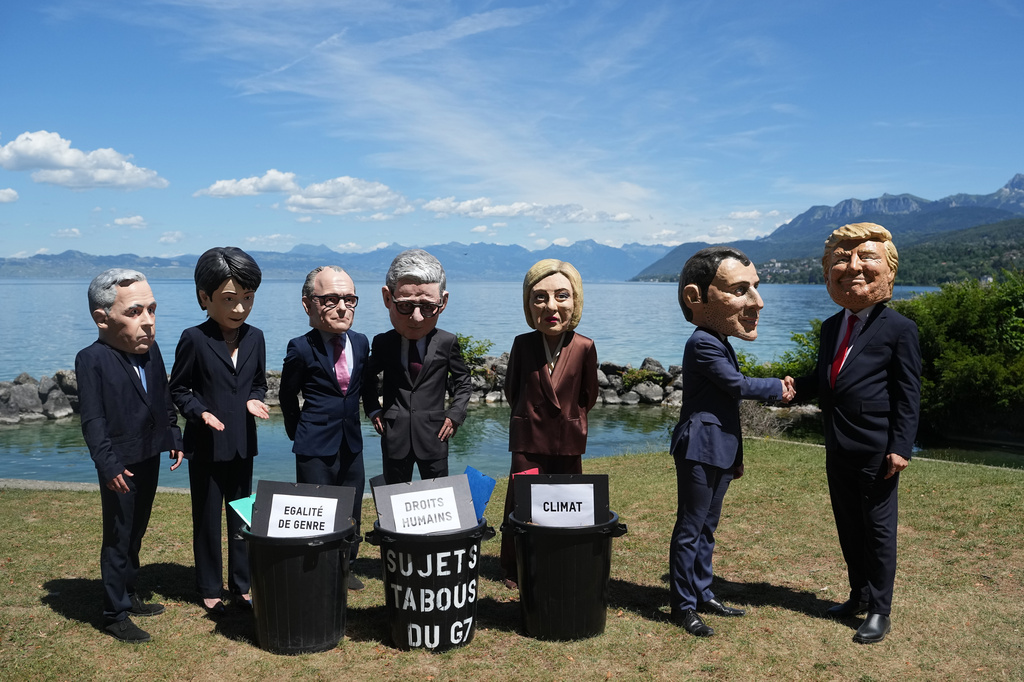 Oxfam's satirical 'big heads' of the G7 leaders pose, in Evian-les-Bains, France, Sunday, June 14, 2026, ahead of the G7 summit scheduled to take place in France June 15-17. (AP Photo/Thibault Camus)