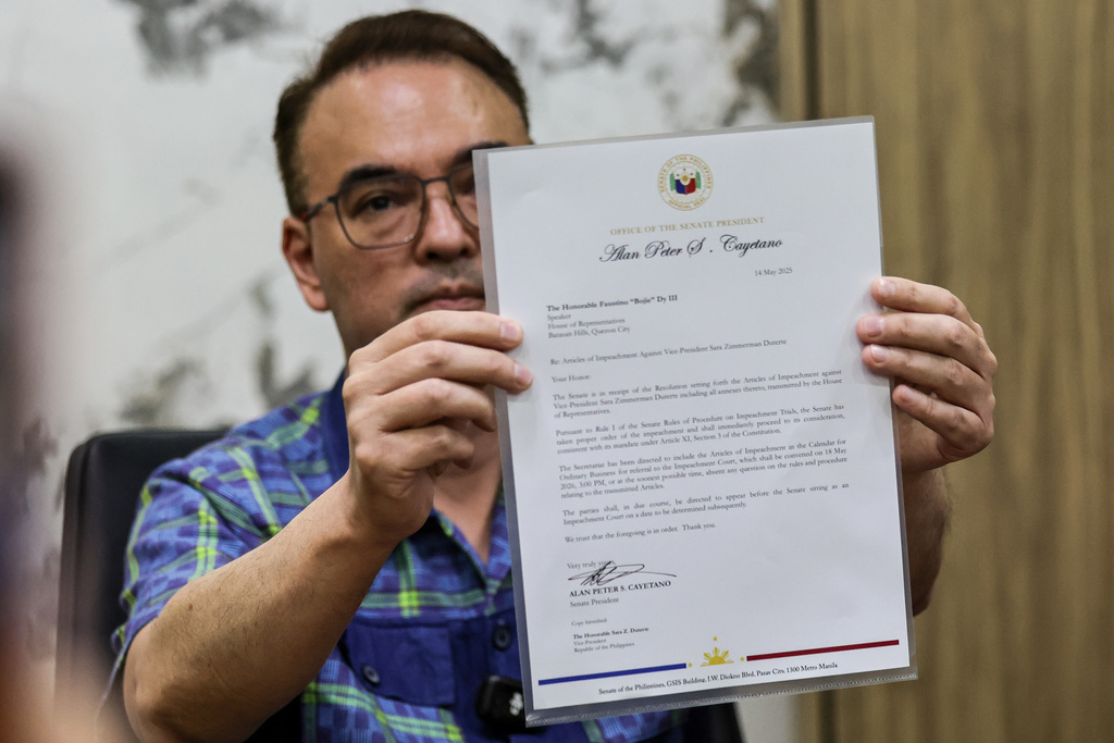 Philippine Senate President Alan Peter Cayetano holds a letter addressed to Lower House Speaker Faustino Dy III, acknowledging the Senate's receipt of the resolution containing the Articles of Impeachment against Vice President Sara Duterte, during a media briefing at the Senate in Pasay City on May 14, 2026.(AP Photo/Gerard Carreon)