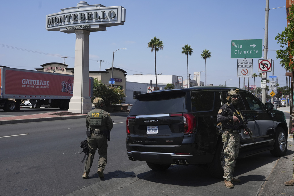 Immigration agents conduct an operation at a car wash on Friday, Aug. 15, 2025, in Montebello, Calif. (AP Photo/Gregory Bull)
