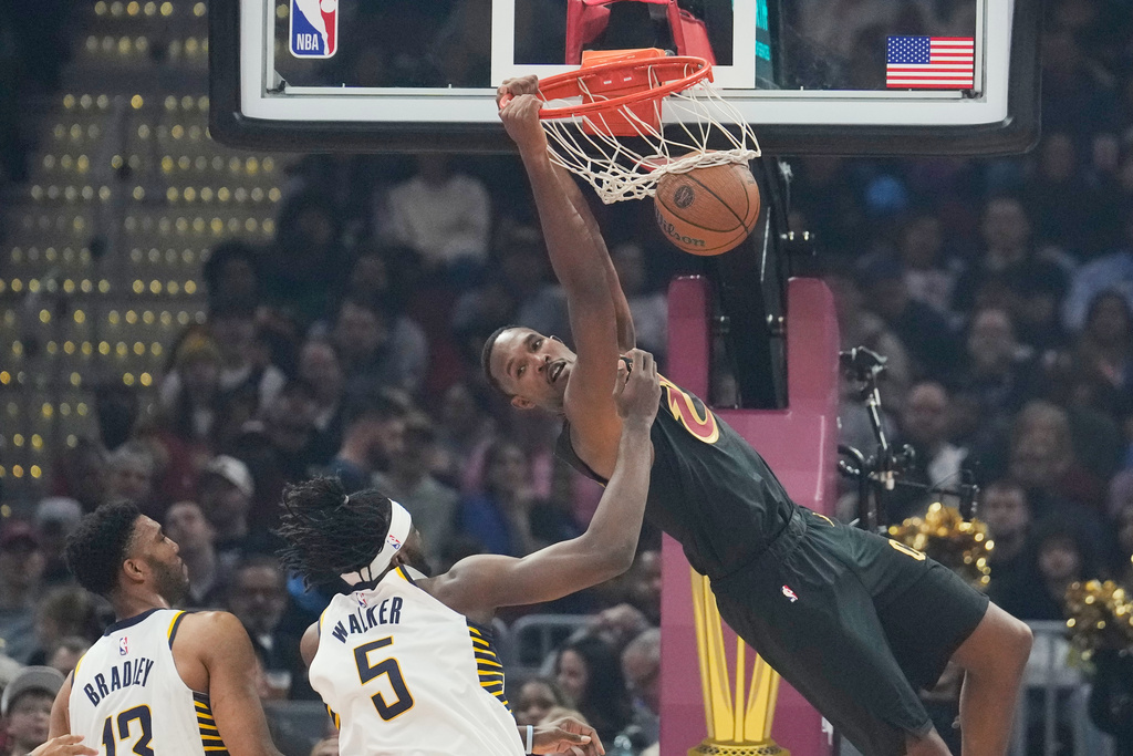 Cleveland Cavaliers center Evan Mobley, right, dunks in front of Indiana Pacers center Tony Bradley (13) and forward Jarace Walker (5) in the first half of an NBA Cup basketball game Friday, Nov. 21, 2025, in Cleveland. (AP Photo/Sue Ogrocki)