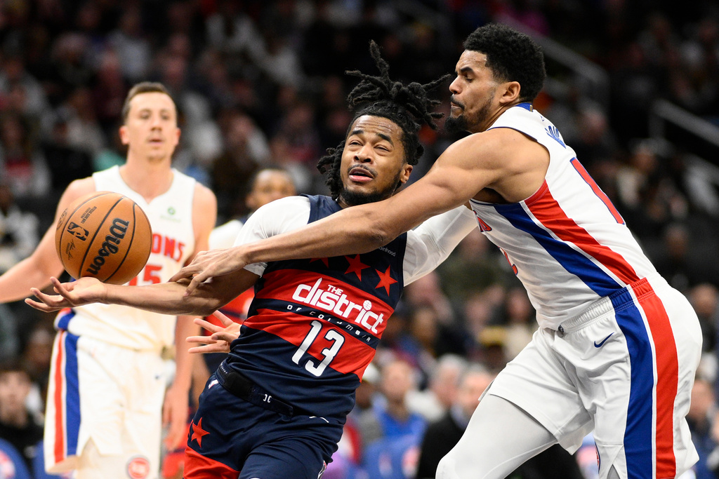 Detroit Pistons forward Tobias Harris, right, knocks the ball away from Washington Wizards guard Sharife Cooper (13) during the first half of an NBA basketball game, Thursday, March 19, 2026, in Washington. (AP Photo/Nick Wass)