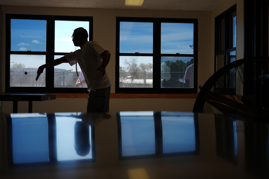 A person who is incarcerated plays ping pong while some windows block light with a reflective coating, meant to lower indoor temperatures, at a Minnesota Correctional Facility in Lino Lakes, Minn., Tuesday, Sept. 15, 2026. (AP Photo/Ellen Schmidt)