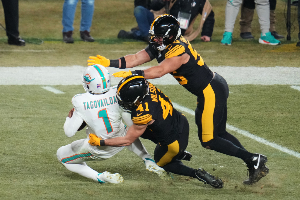 Miami Dolphins quarterback Tua Tagovailoa (1) is sacked by Pittsburgh Steelers' Payton Wilson (41) and Alex Highsmith (56) in the second half of an NFL football game in Pittsburgh, Monday, Dec. 15, 2025. (AP Photo/Gene J. Puskar)