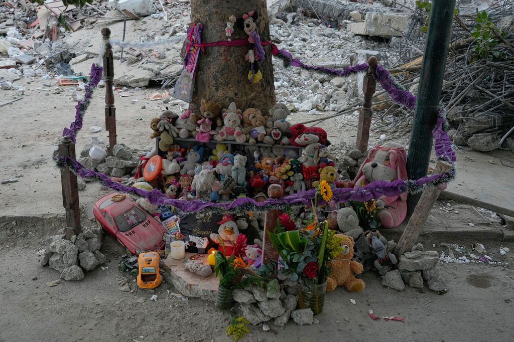 Stuffed animals and toys found at the OPP 25 residential building, which collapsed during the earthquake, are piled into a makeshift memorial in La Guaira, Venezuela, Friday, July 17, 2026. (AP Photo/Ariana Cubillos)