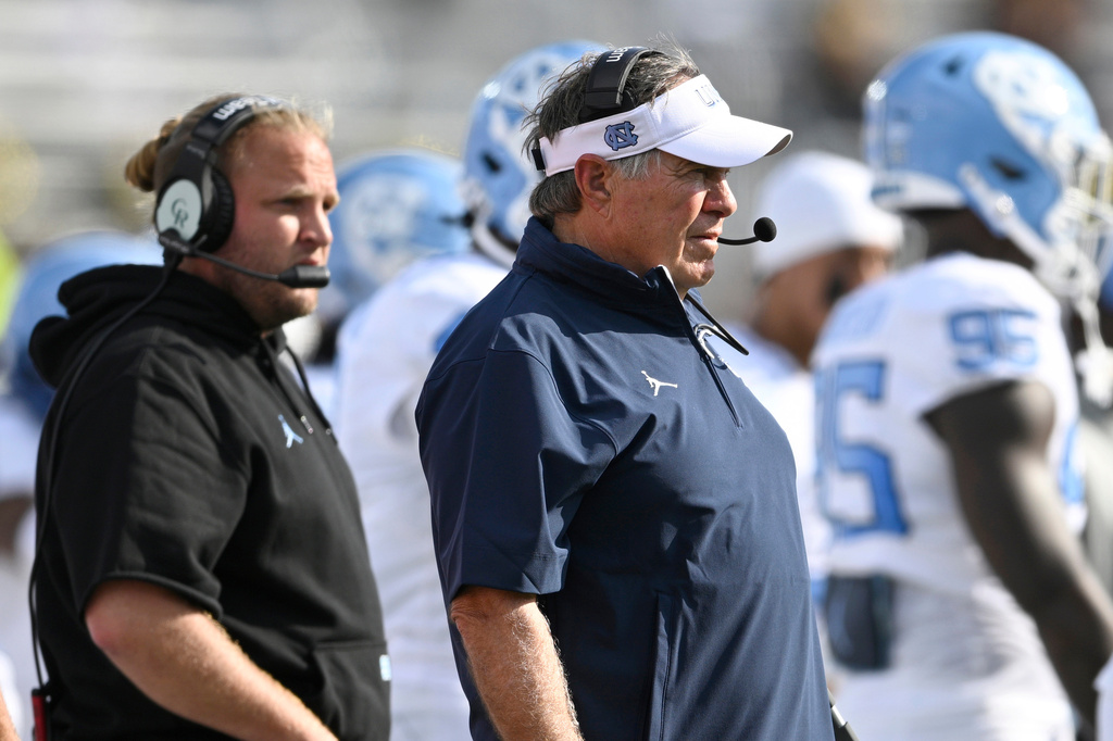 FILE - North Carolina head coach Bill Belichick, center, and defensive coordinator Steve Belichick, left, look on during the first half of an NCAA football game against Central Florida, Saturday, Sept. 20, 2025, in Orlando, Fla. (AP Photo/Phelan M. Ebenhack, File)