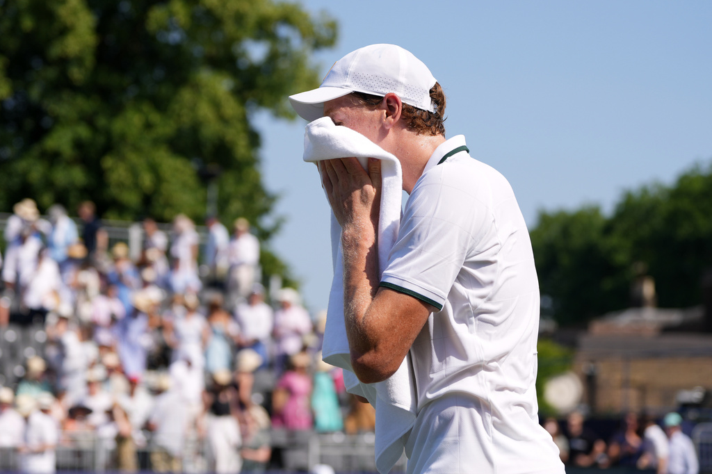 Jannik Sinner of Italy uses a towel to wipe his face during a tennis exhibition match against Cameron Norrie of Great Britain at the Hurlingham Tennis Club in London, Wednesday, June 24, 2026.(AP Photo/Kirsty Wigglesworth)