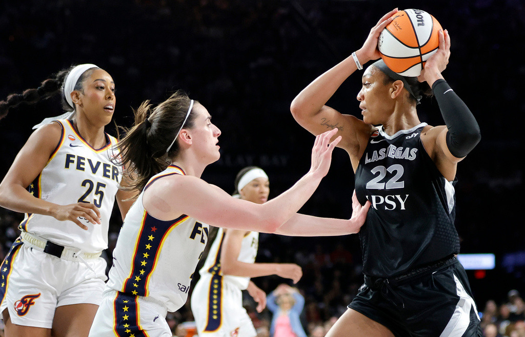 Indiana Fever forward Monique Billings (25) and guard Caitlin Clark, center, put pressure on Las Vegas Aces center A'ja Wilson (22) during the second half in Game 1 of a WNBA basketball first-round playoff series Sunday, Sept. 27, 2026, in Las Vegas. (AP Photo/Steve Marcus)