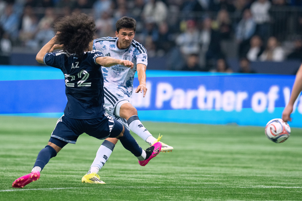 San Jose Earthquakes' Beau Leroux kicks the ball as Vancouver Whitecaps' Aziel Jackson (22) defends during the first half of an MLS soccer game in Vancouver, Saturday, March 21, 2026. (Ethan Cairns/The Canadian Press via AP)