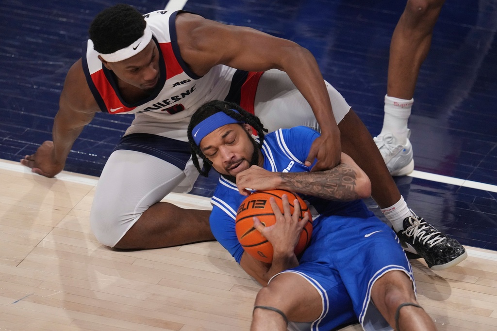 Saint Louis guard Trey Green, bottom, battles Duquesne forward Alex Williams for a loose ball during the first half an NCAA college basketball game in Pittsburgh, Tuesday, Jan. 20, 2026. (AP Photo/Gene J. Puskar)