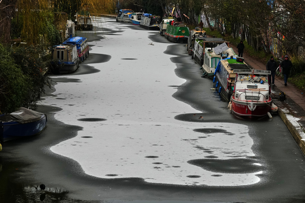 Narrowboats are anchored on a frozen canal after light snowfall in London, Tuesday, Jan. 6, 2026 as new warnings have been issued for more wintry weather. (AP Photo/Frank Augstein)