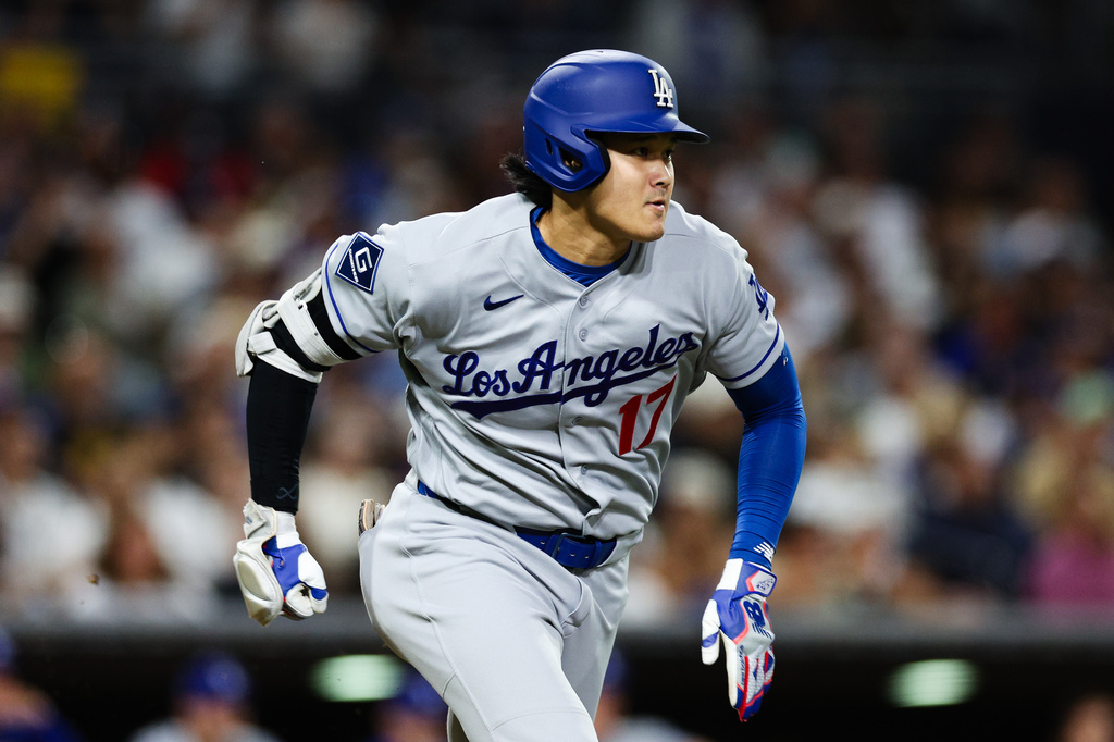 Los Angeles Dodgers' Shohei Ohtani runs to first after hitting a ground ball to San Diego Padres' Ty France for an out in the sixth inning of a baseball game Friday, June 26, 2026, in San Diego. (AP Photo/Derrick Tuskan)