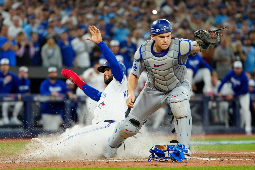 FILE - Toronto Blue Jays' Isiah Kiner-Falefa, left, is forced out at home plate by Los Angeles Dodgers catcher Will Smith during the ninth inning in Game 7 of baseball's World Series in Toronto on Nov. 1, 2025. (Frank Gunn/The Canadian Press via AP, File)