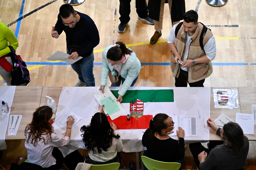 A woman takes ballots at a polling station during the Hungarian parliamentary election in Budapest, Hungary, Sunday, April 12, 2026. (AP Photo/Denes Erdos)