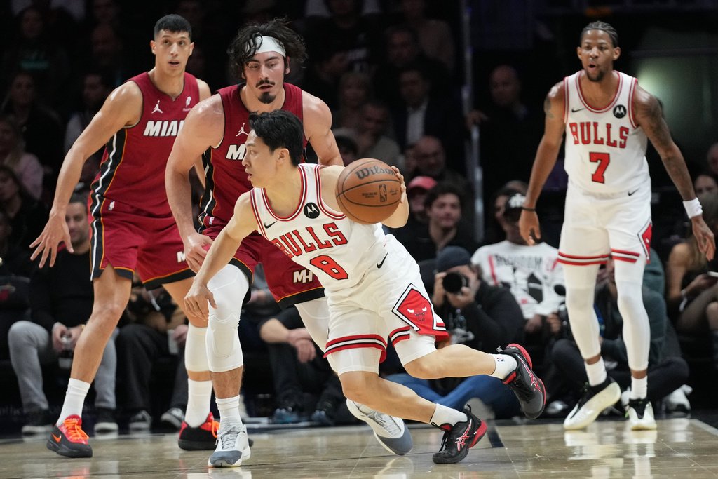 Chicago Bulls guard Yuki Kawamura (8) drives to the basket as Miami Heat forward Jaime Jaquez Jr., second from left, defends during the first half of an NBA basketball game, Saturday, Jan. 31, 2026, in Miami. (AP Photo/Lynne Sladky)