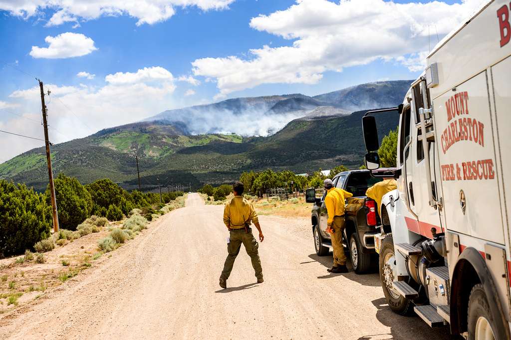 A firefighter watches as the Cottonwood Fire burns near Beaver, Utah, on Saturday, June 27, 2026. (AP Photo/Noah Berger)