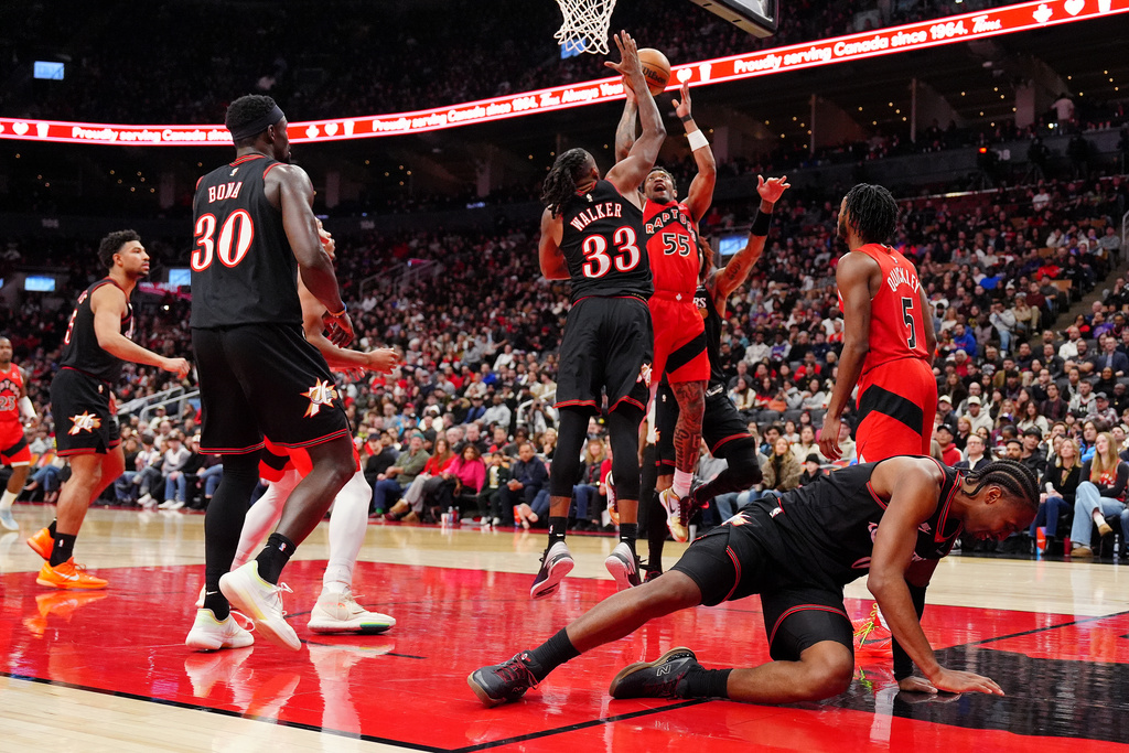 Philadelphia 76ers guard Tyrese Maxey, bottom right, rolls on the court as play continues behind him during first-half NBA basketball game action against the Toronto Raptors in Toronto, Sunday, Jan. 11, 2026. (Frank Gunn/The Canadian Press via AP)