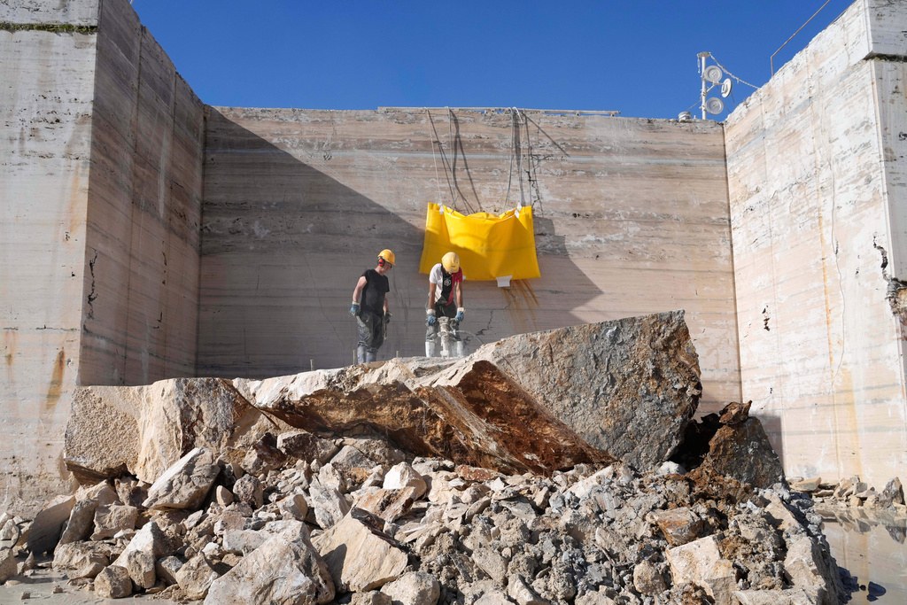 Workers use a jackhammer to break a block of travertine at the Degemar Quarry near Tivoli, Italy, 35 kilometers east of Rome, on Friday, Feb. 13, 2026, where 17th-century Baroque architect Gian Lorenzo Bernini selected travertine for the colonnade of St. Peter's Square. (AP Photo/Gregorio Borgia)