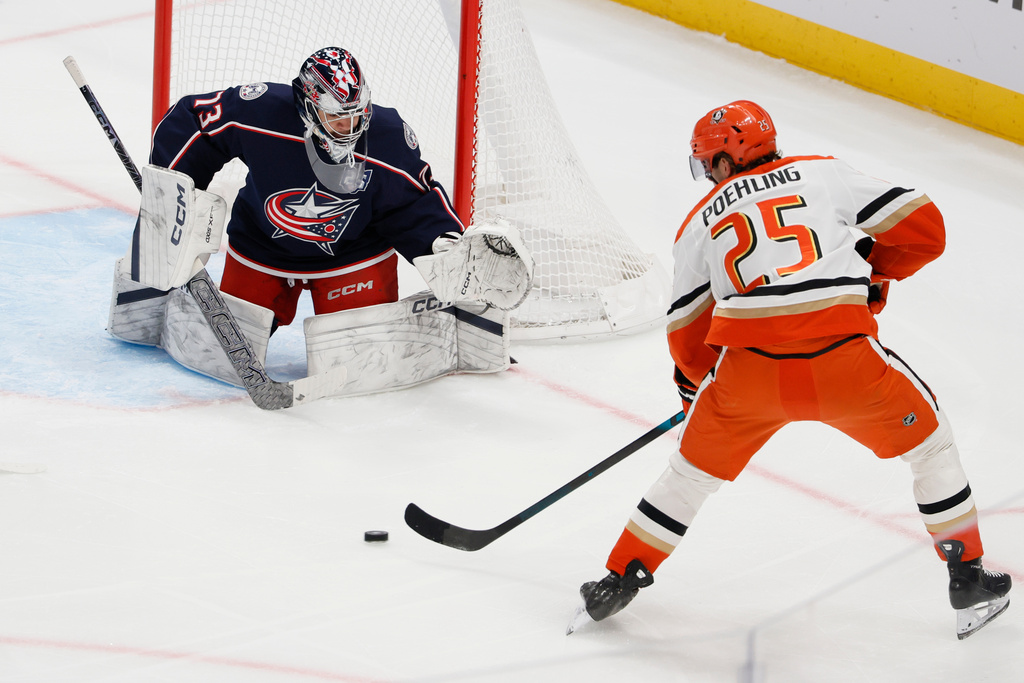 Columbus Blue Jackets' Jet Greaves, left, makes a save against Anaheim Ducks' Ryan Poehling during the second period of an NHL hockey game, Tuesday, Dec. 16, 2025, in Columbus, Ohio. (AP Photo/Jay LaPrete)