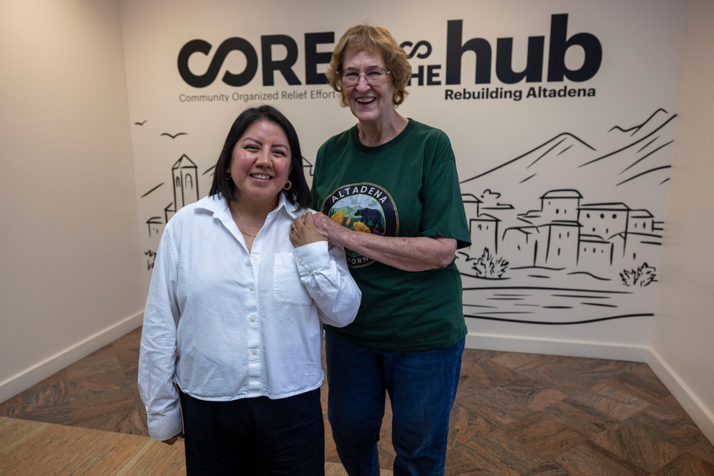Veda Ashby Romero, left, a disaster case manager for CORE, poses for a portrait with Mary Landau, a fire survivor, at the CORE resource center on Thursday, Oct. 15, 2026, in Altadena, Calif. (AP Photo/Jill Connelly)