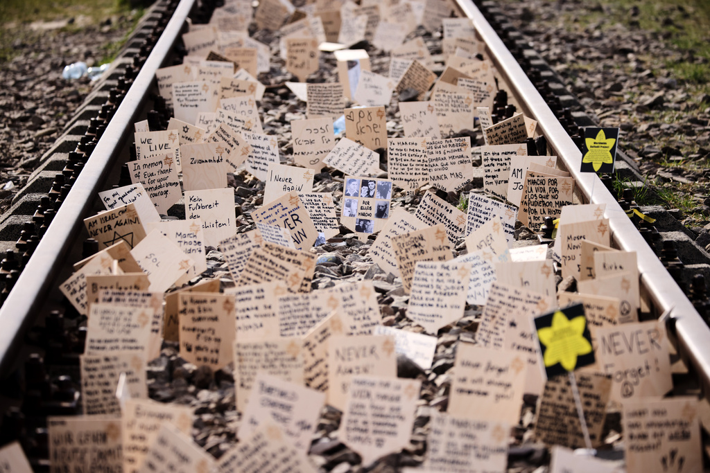 Signs are put between the rails during the annual "March of the Living" to commemorate the Holocaust, a yearly Holocaust remembrance march between the former death camps of Auschwitz and Birkenau, in Oswiecim, Poland, on Tuesday, April 14, 2026. (AP Photo/Beata Zawrzel)
