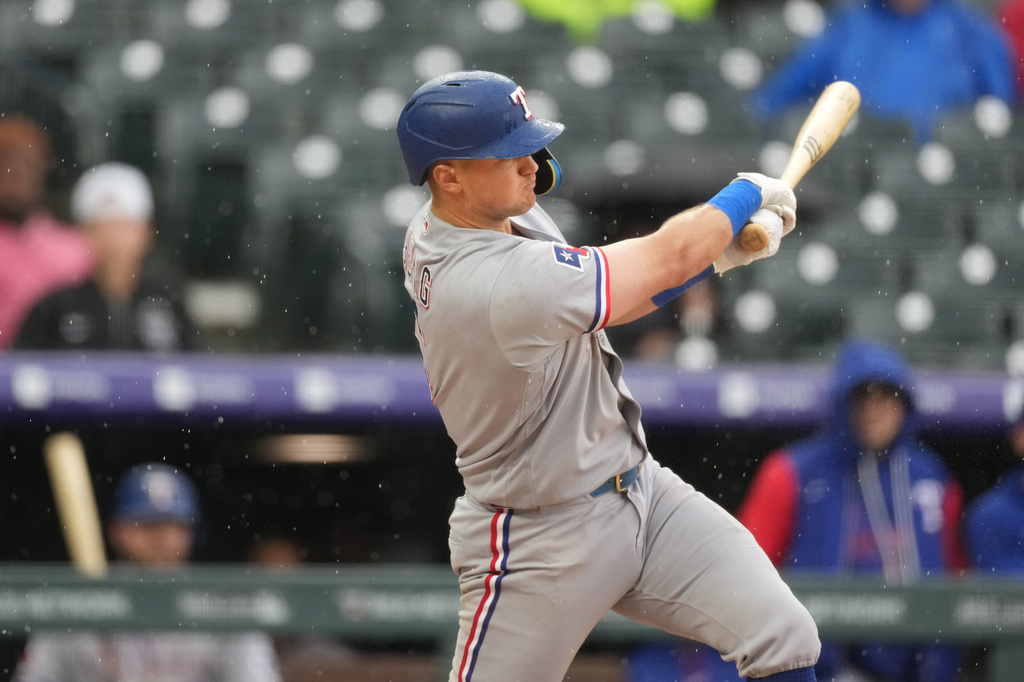 Texas Rangers' Josh Jung hits an RBI single to drive in the go-ahead run off Colorado Rockies pitcher Juan Mejia in the ninth inning of a baseball game Wednesday, May 20, 2026, in Denver. (AP Photo/David Zalubowski)