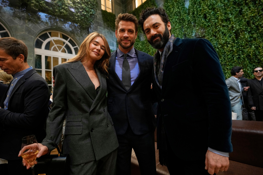 Liam Hemsworth, center, flanked by his girlfriend, model, Gabriella Brooks, and Morgan Spector, as they attend Ralph Lauren Fall/Winter 2026-2027 Men's fashion show presented in Milan, Italy, Friday, Jan. 16, 2026. (AP Photo/Luca Bruno)