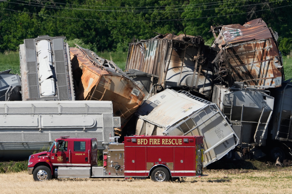 A fire truck sits near damage after a train derailed on Wednesday, June 3, 2026, near Victor, Iowa. (AP Photo/Charlie Neibergall)