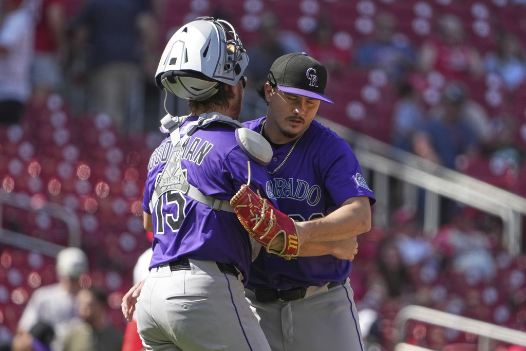Colorado Rockies' Hunter Goodman, left, and Victor Vodnik celebrate a victory over the St. Louis Cardinals following a baseball game Wednesday, Aug. 13, 2025, in St. Louis. (AP Photo/Jeff Roberson)