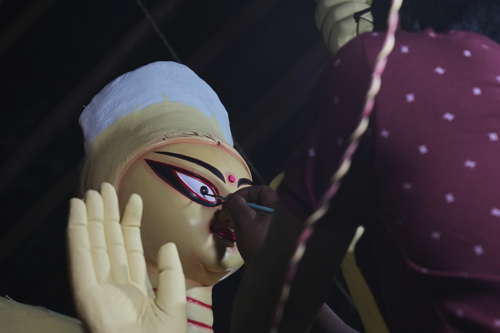 Govind Nath from Kolkata paints the eye of an idol of the Hindu goddess Durga ahead of the Durga Puja festival in New Delhi, India, Friday, Sept. 19, 2025. (AP Photo/Manish Swarup)