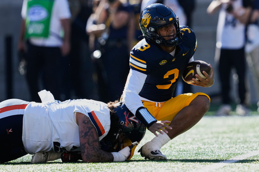 California quarterback Jaron-Keawe Sagapolutele (3) is sacked by Virginia defensive lineman Jacob Holmes (23) during the first half of an NCAA college football game, Saturday, Nov. 1, 2025, in Berkeley, Calif. (AP Photo/Godofredo A. Vásquez)