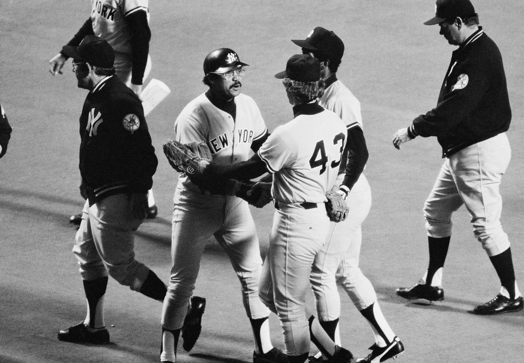 FILE - Yankees' Reggie Jackson, center, who hit a three-run home run, and Ken Clay, who pitched more than three innings without giving up a hit, congratulate each other as New York won the American League playoff opener over Kansas City, Oct. 3, 1978, Kansas City, Mo. (AP Photo/Ray Stubblebine, file)