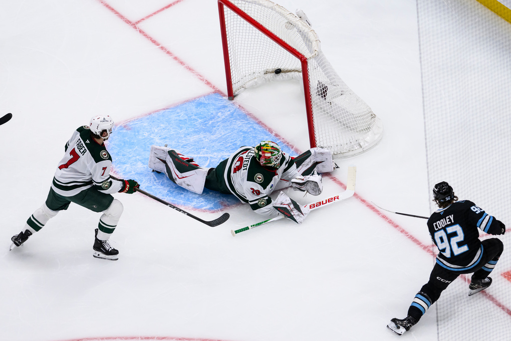 Utah Mammoth center Logan Cooley (92) scores a a short-handed goal against Minnesota Wild goaltender Jesper Wallstedt, center, during the first period of an NHL hockey game, Friday, Feb. 27, 2026, in Salt Lake City. (AP Photo/Tyler Tate)