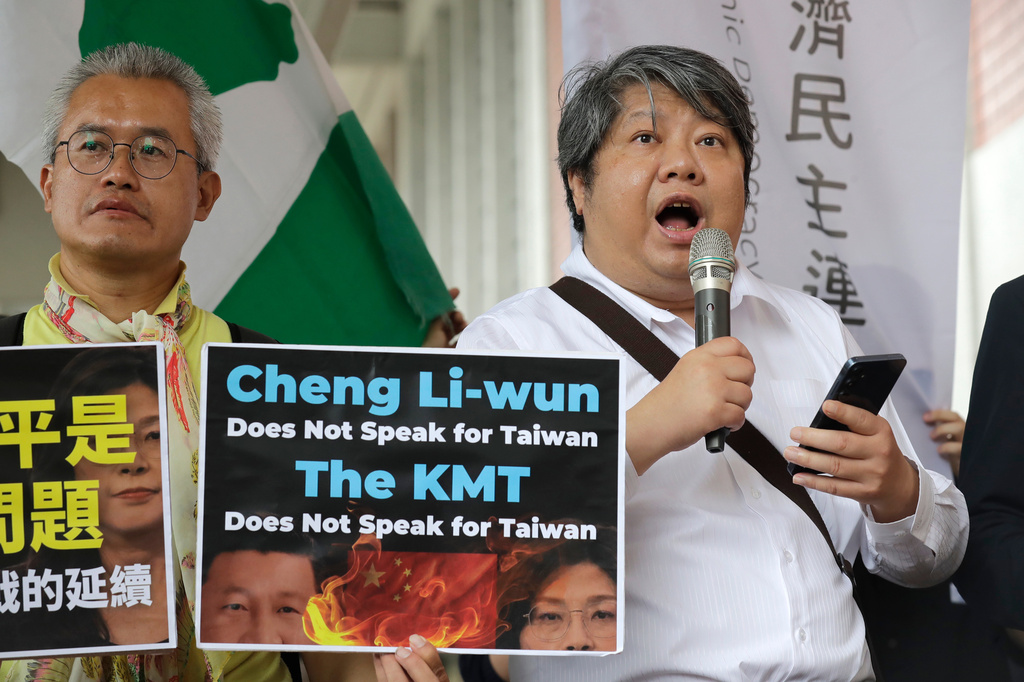 A protester delivers a speech as Taiwan's main opposition Nationalist Party, or Kuomintang (KMT) chairperson Cheng Li-wun leaves for China, outside of Taipei Songshan Airport in Taipei, Taiwan, Tuesday, April 7, 2026. (AP Photo/Chiang Ying-ying)