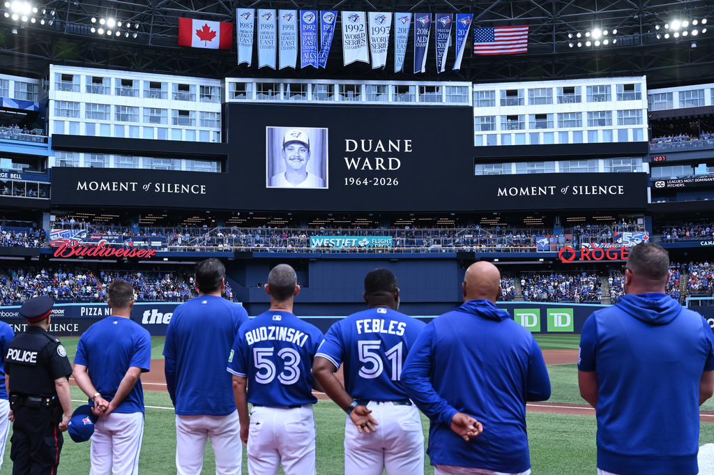 Players and coaches of the Toronto Blue Jays recognize a moment of silence on the announcement of the passing of former Blue Jays pitcher Duane Ward prior to the start of the game against the Chicago White Sox in MLB baseball action in Toronto on Sunday, July 19, 2026. (Jon Blacker/The Canadian Press via AP)
