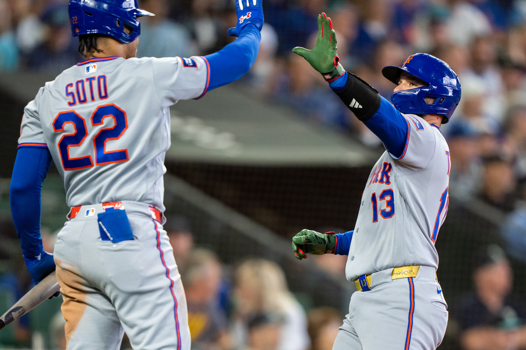 New York Mets' Luis Torrens is congratulated by Juan Soto after scoring a run during the eighth inning of a baseball game against the Seattle Mariners, Wednesday, June 3, 2026, in Seattle. (AP Photo/Stephen Brashear)
