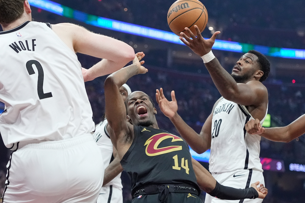 Cleveland Cavaliers guard Keon Ellis (14) celebrates his dunk between Brooklyn Nets forward Danny Wolf (2) and center Day'ron Sharpe (20) in the first half of an NBA basketball game in Cleveland, Thursday, Feb. 19, 2026. (AP Photo/Sue Ogrocki)