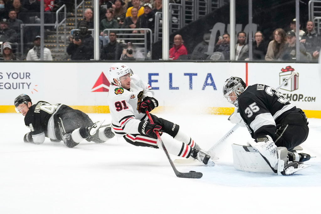 Chicago Blackhawks center Frank Nazar, center, tries to score on Los Angeles Kings goaltender Darcy Kuemper, right, as defenseman Mikey Anderson falls during the third period of an NHL hockey game Thursday, Dec. 4, 2025, in Los Angeles. (AP Photo/Mark J. Terrill)