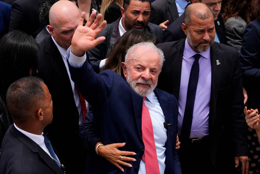 Brazilian President Luiz Inacio Lula da Silva waves after a ceremony marking the three year anniversary of a failed attempt to overthrow Brazil’s democratic system, as his wife Rosangela da Silva embraces him, at Planalto presidential palace in Brasilia, Brazil, Thursday, Jan. 8, 2026. Lula's wife Rosangela da Silva walks next to him, wrapping her arms around him. (AP Photo/Eraldo Peres)