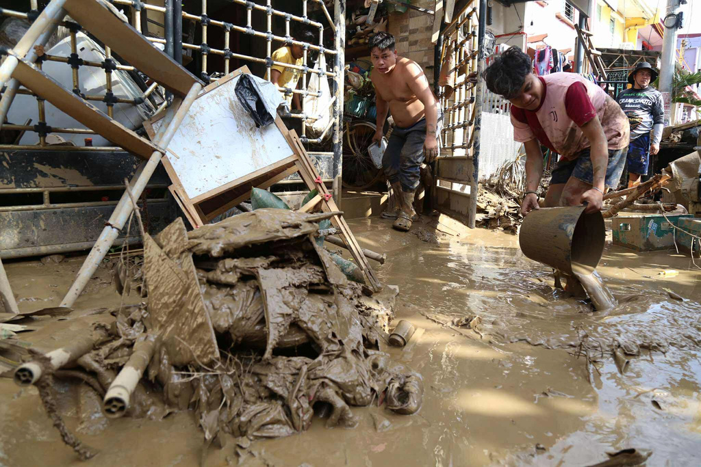 Residents clean up outside their homes after Typhoon Kalmaegi caused devastation in communities at Talisay City, Cebu province, central Philippines, Wednesday, Nov. 5, 2025. (AP Photo/Jacqueline Hernandez)
